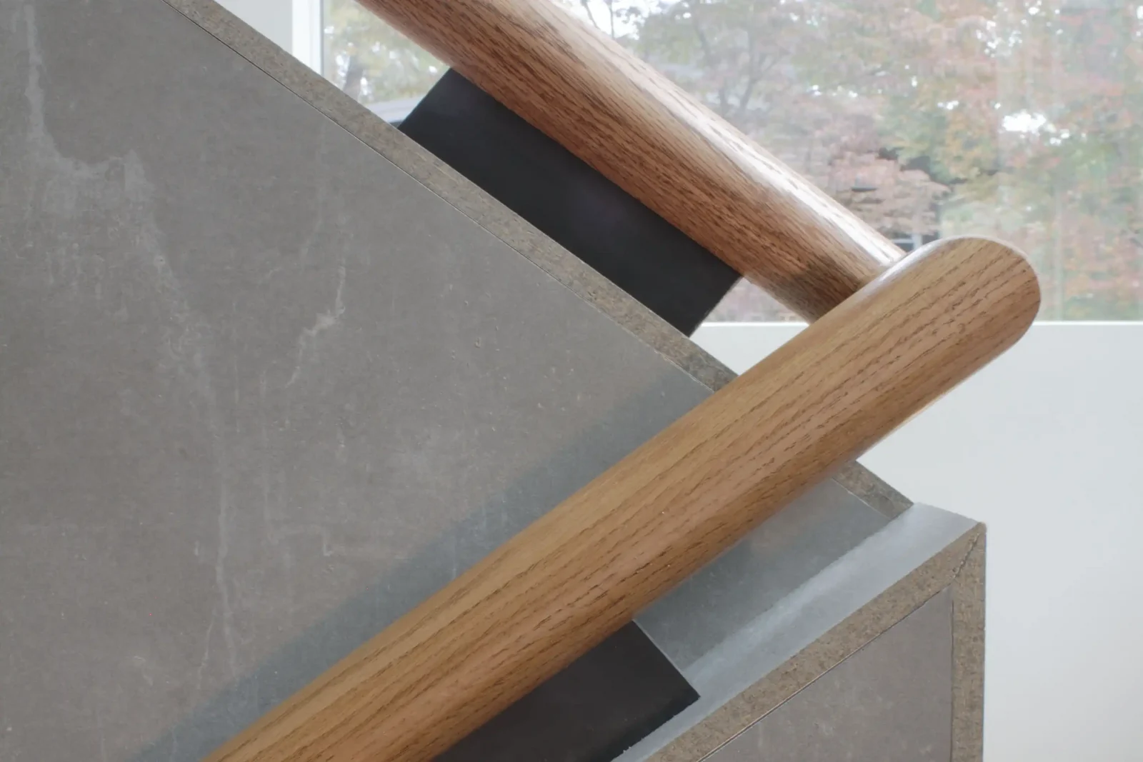 Close-up view of custom modern stair handrail bracket 