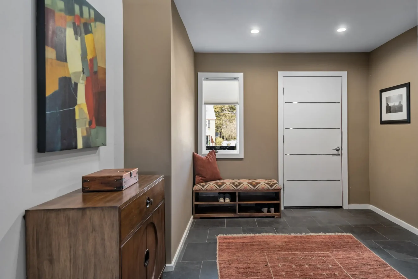 View of foyer showing cutom front door, slate flooring and white trim