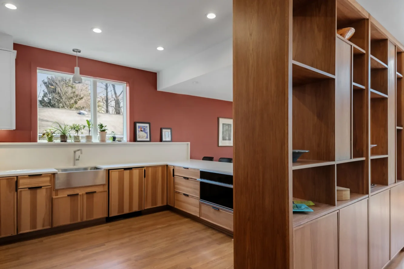 View of kitchen through new custom room dividing built-in cabinetry